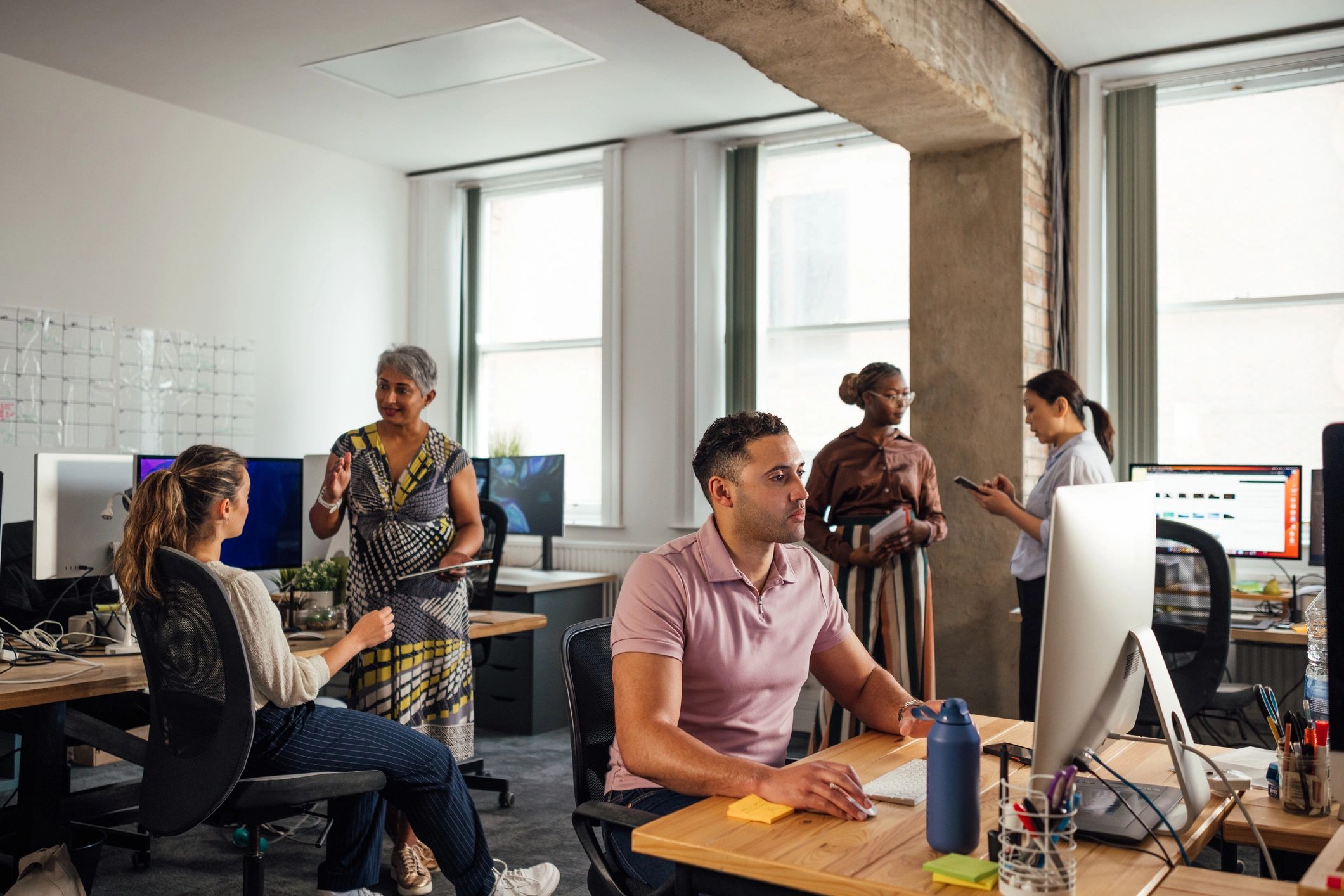 Office worker collaborating with team in a modern workspace